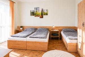 a bedroom with two beds and a painting on the wall at Chata Bystřička in Velká Lhota