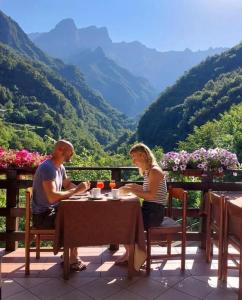 a man and woman sitting at a table with a view at Hotel Al Verde in Mandello del Lario