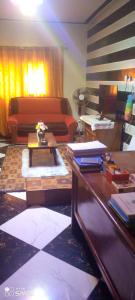 a living room with a couch and a table at Chambre d'hôtes à louer in Pikine +4 photos
