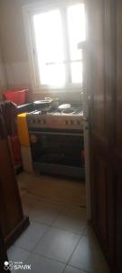 a stove in a kitchen with a window at Chambre d'hôtes à louer in Pikine