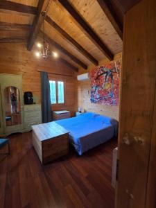 a bedroom with a blue bed in a wooden room at La Baita di Lusso Bagnone in Bagnone