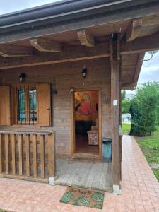 a wooden house with a door and a porch at La Baita di Lusso Bagnone in Bagnone