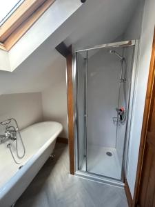 a bathroom with a shower and a bath tub at Herberts Cottage in Wormegay +16 photos