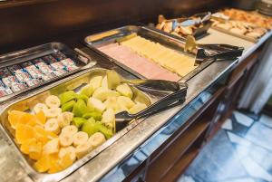 a buffet line with trays of vegetables and cheese at Hotel Selent in Mar del Plata