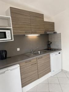 a kitchen with a sink and a microwave at Charmant studio avec terrasse in Fréjus