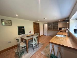 a kitchen with a table and chairs in a kitchen at Herberts Cottage in Wormegay
