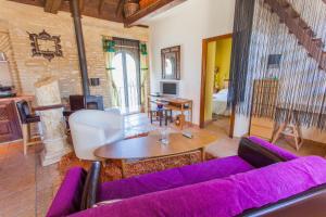 a living room with a purple couch and a table at Atico Sanlucar in Sanlúcar de Barrameda