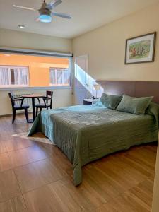 a bedroom with a bed and a table with chairs at Los Nogales de Tatash in Centenario