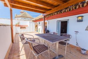 a wooden table and chairs on a patio at Atico Sanlucar in Sanlúcar de Barrameda