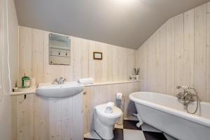 a bathroom with a tub and a toilet and a sink at 2 Bed in Woodchurch oc-b30323 in Woodchurch +17 photos
