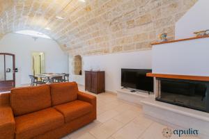 a living room with a couch and a fireplace at Villa Stone and Sea Escape by Apulia Accommodation in Cozze