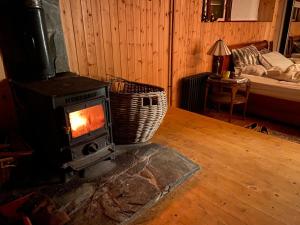 a woodburning stove in a room with a bed at Sanctuary Apartment nestled in nature in Westport