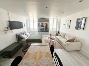 a living room with a table and a couch at Appartement Standing proche des Thermes in Vichy