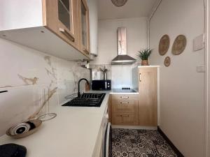 a small kitchen with a sink and a stove at Appartement Standing proche des Thermes in Vichy +8 photos