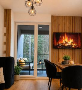 a living room with a fireplace and a table with chairs at Oaza in Sarajevo