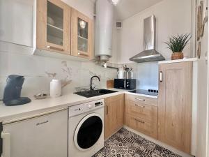 a kitchen with a washing machine and a sink at Appartement Standing proche des Thermes in Vichy