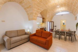 a living room with a couch and a table at Villa Stone and Sea Escape by Apulia Accommodation in Cozze