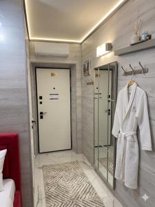 a dressing room with a white robe on a rack at Ismail 94-1 Apartments in Chişinău