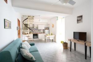 a living room with a blue couch and a kitchen at Mimì sul Mare in Massa Lubrense