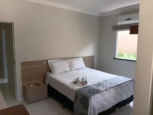 a bedroom with a bed with two shoes on it at Casa Melcon in Aquiraz