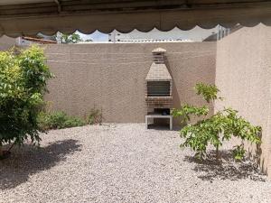 a brick wall with a grill in a yard at Casa Melcon in Aquiraz