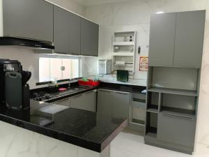 a kitchen with white cabinets and black counter tops at Casa Melcon in Aquiraz