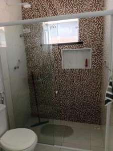 a bathroom with a glass shower with a toilet at Casa Melcon in Aquiraz +8 photos