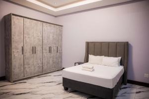 a bedroom with a large bed and wooden cabinets at Oasis Apartment Suites in Ezulwini