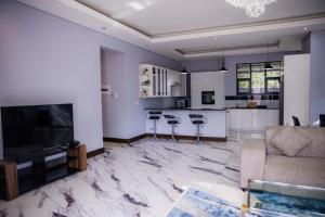 a living room with a couch and a kitchen at Oasis Apartment Suites in Ezulwini