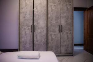 a bedroom with a bed and two metal cabinets at Oasis Apartment Suites in Ezulwini +46 photos