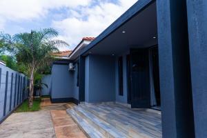a house with a blue wall and a patio at Oasis Apartment Suites in Ezulwini