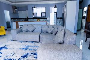 a living room with a couch and a kitchen at Oasis Apartment Suites in Ezulwini