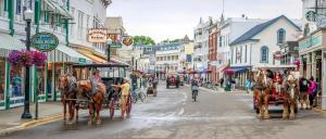 a horse drawn carriage on a city street at Above Mustang Condos in Mackinac Island