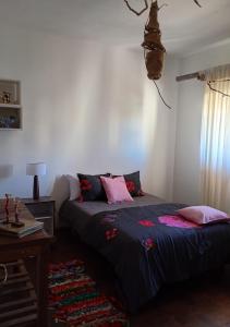 a bedroom with a bed and a table and a window at Casa JINDRA in Puerto Madryn