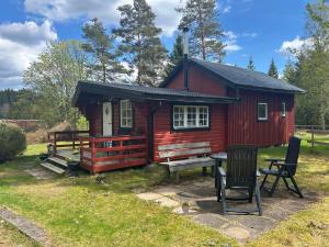eine rote Hütte mit einem Picknicktisch davor in der Unterkunft Farmstay Götes Cabin, 2p in Årjäng