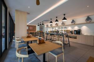 a restaurant with tables and chairs and a kitchen at PAAK Hotel Suvarnabhumi in Lat Krabang