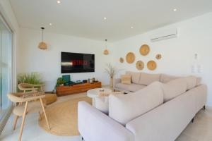 a living room with a white couch and a tv at Paradise Villa Sky - Signature by Paradise Portugal in Ribamar