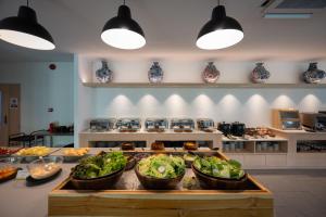 a kitchen with four bowls of vegetables on a counter at PAAK Hotel Suvarnabhumi in Lat Krabang