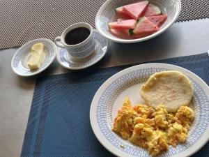 a table with two plates of food and a cup of coffee at Posada Rural Aguita de Panela in La Vega