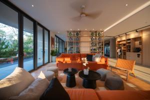 a living room with an orange couch and a table at PAAK Hotel Suvarnabhumi in Lat Krabang