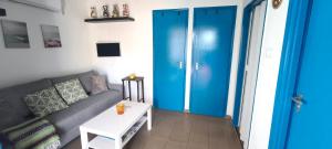 a living room with a couch and a blue door at A Görög kis Ház in Velence