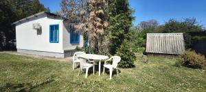 a table and chairs in a yard with a house at A Görög kis Ház in Velence