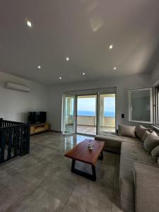 a living room with a couch and a table at Infinite Blue Maisonette with Panoramic Terrace in Ámpelos