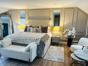 a bedroom with a large bed and a chair at Brackengarth House in Purdysburn