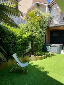two lawn chairs sitting on the grass in a yard at Suite indépendante avec jardin, 2 chambres communicantes, hyper centre Arcachon in Arcachon