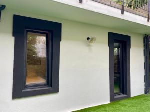 two windows on the side of a white building at Suite indépendante avec jardin, 2 chambres communicantes, hyper centre Arcachon in Arcachon