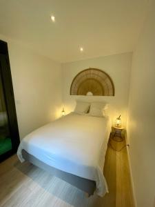 a bedroom with a large bed with white sheets at Suite indépendante avec jardin, 2 chambres communicantes, hyper centre Arcachon in Arcachon