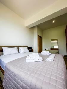 a bedroom with a large bed with towels on it at Infinite Blue Maisonette with Panoramic Terrace in Ámpelos