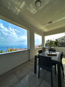 a dining room with a table and chairs and a large window at Infinite Blue Maisonette with Panoramic Terrace in Ámpelos