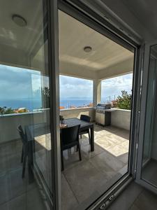 a balcony with a table and a view of the ocean at Infinite Blue Maisonette with Panoramic Terrace in Ámpelos
